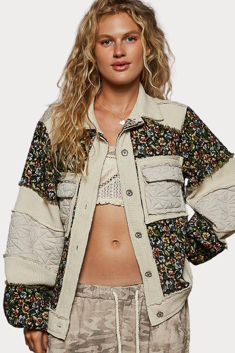 Woman wearing a floral and beige jacket with a neutral background