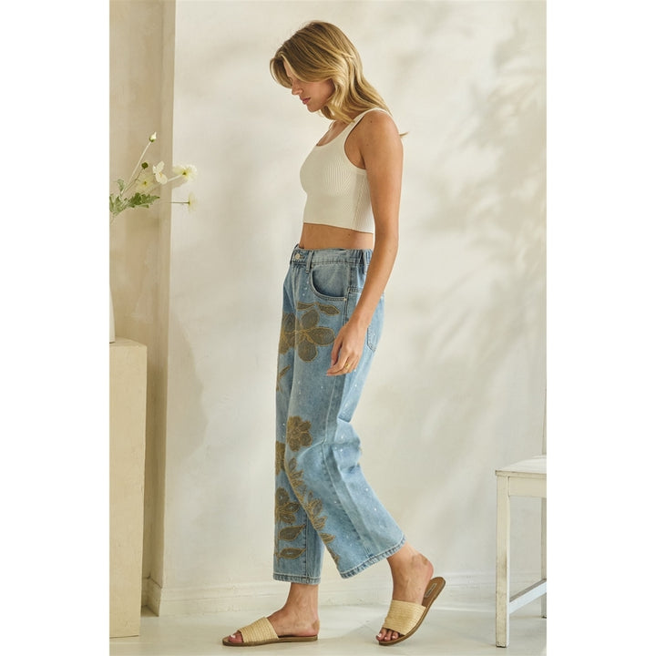 Woman wearing a white top and blue jeans standing in a minimalistic room.