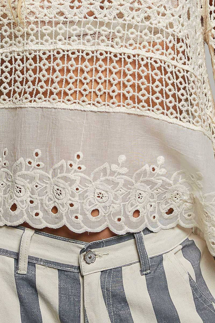Model wearing The Briar Rose Crochet Blouse featuring intricate open crochet, embroidered eyelet cotton panels, long bell sleeves, and a relaxed bohemian silhouette in ivory.