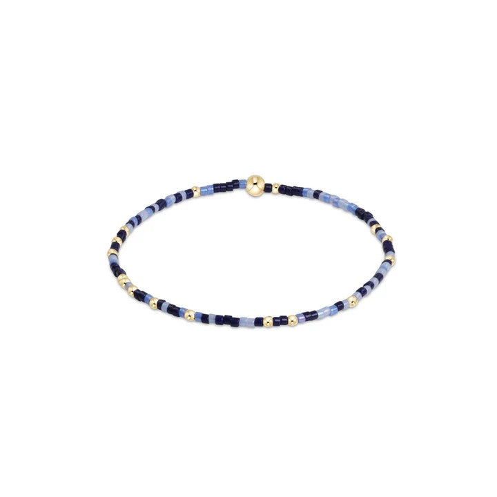 Navy and light blue beaded bracelet with gold accents on elastic band