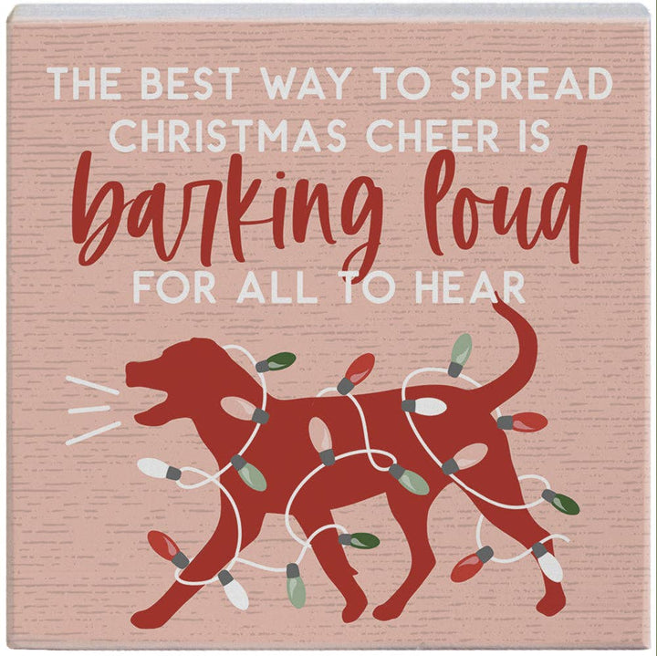 small wood block with dog wrapped in Christmas lights and quote “The best way to spread Christmas cheer is barking loud for all to hear”