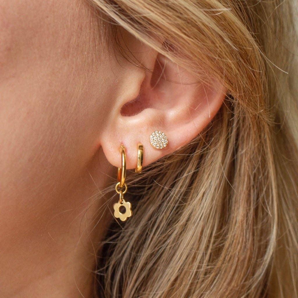 Close-up of an ear wearing gold hoop earrings 
