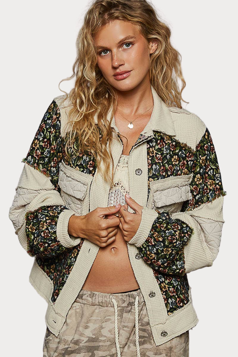 Woman wearing a patterned jacket with a neutral background