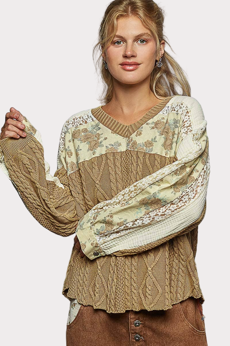 Woman wearing a vintage-wash V-neck sweater with lace and gauze patchwork details, styled in a relaxed boho fit.