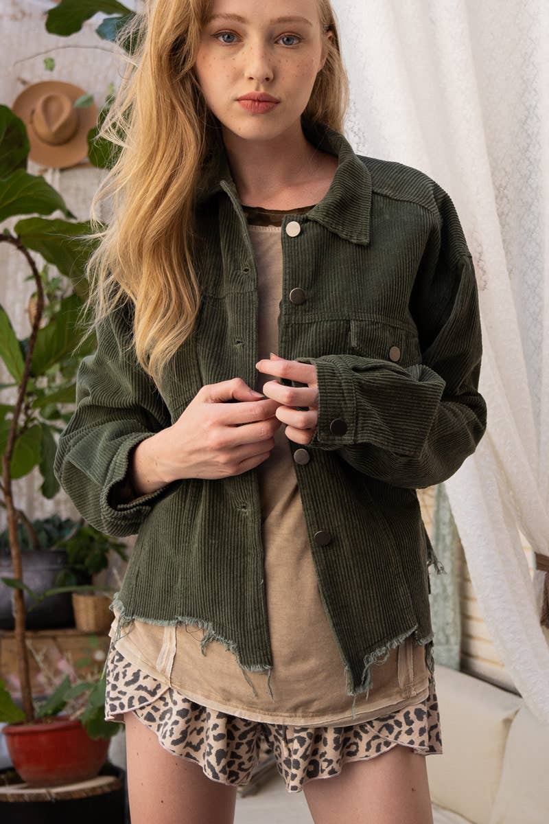 A woman models a relaxed-fit, olive green corduroy jacket with a raw, frayed hem over a tan t-shirt and leopard print shorts.

