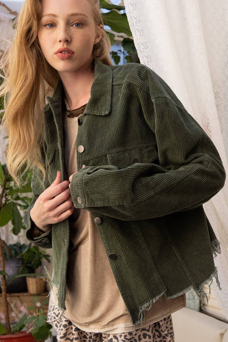 A woman models a relaxed-fit, olive green corduroy jacket with a raw, frayed hem over a tan t-shirt and leopard print pants.

