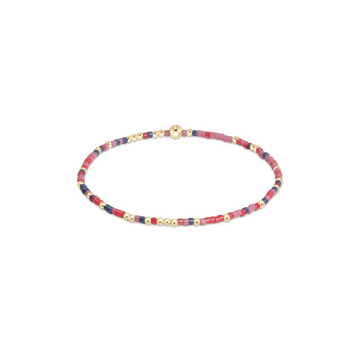 Pink, red, and navy beaded bracelet with 14kt gold accents on elastic band