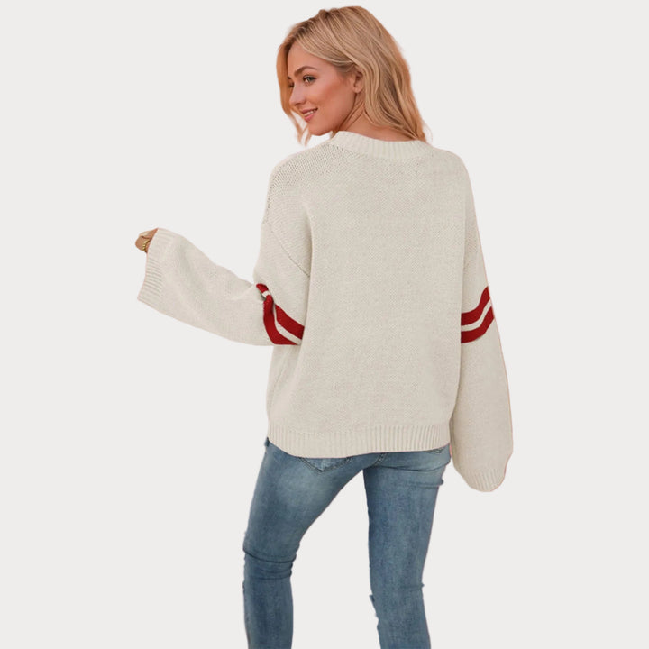 Women’s heart knit sweater pullover with cream base, red heart design, relaxed fit, and crew neckline styled with jeans