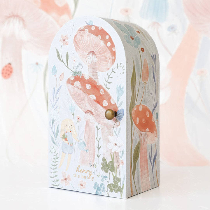 Decorative box with mushroom design and 'henry the bunny' text on a soft background
