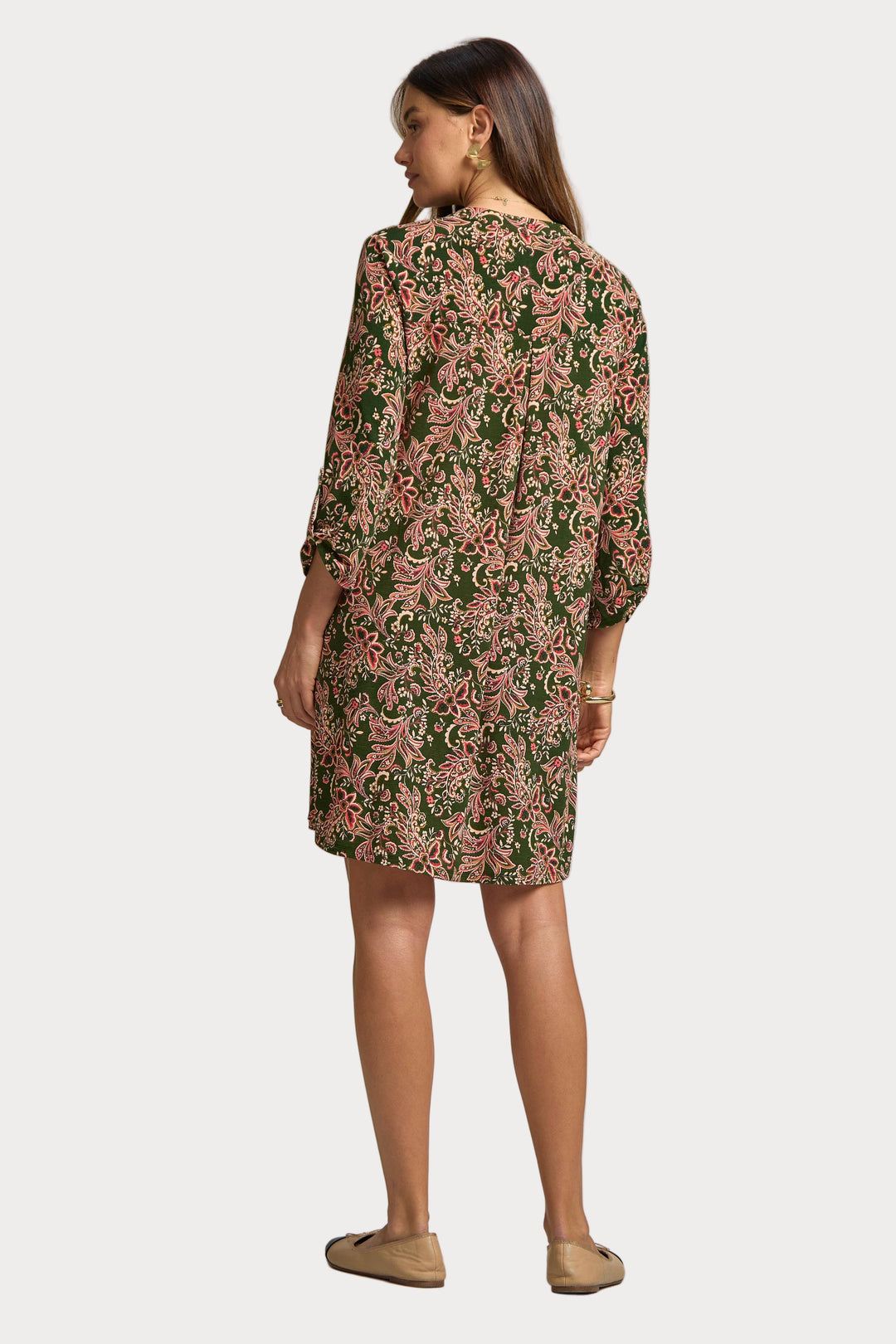 Woman wearing a floral dress on a plain background