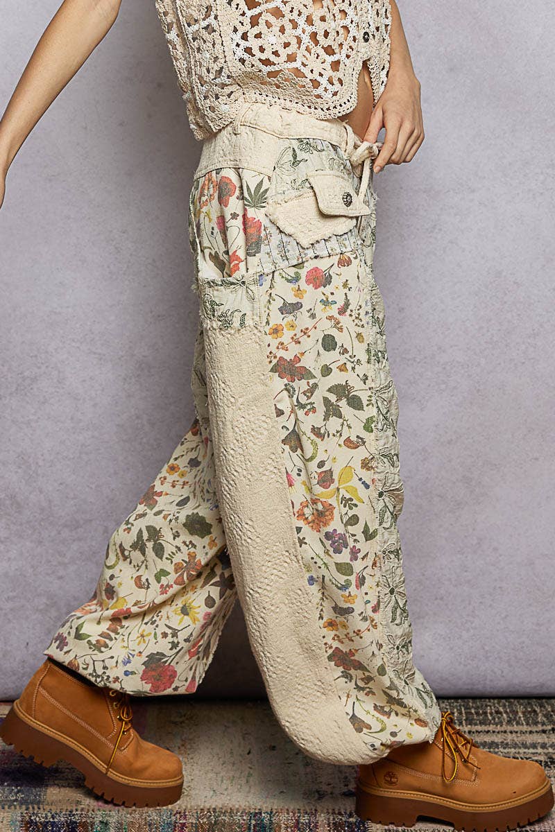 Model wearing The Cottage Bloom Patchwork Joggers by POL featuring vintage-inspired floral patchwork, textured jacquard details, oversized utility pockets, and a relaxed bohemian silhouette.
