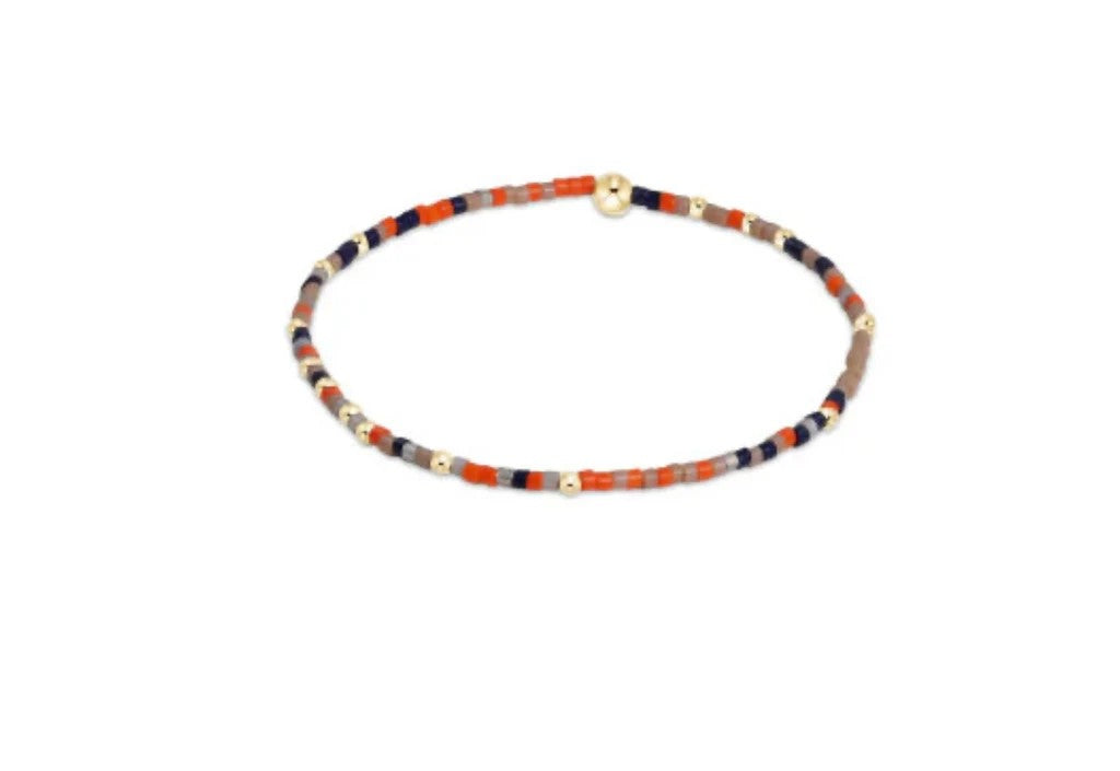 Orange, navy, and taupe beaded bracelet with 14kt gold accents on elastic band