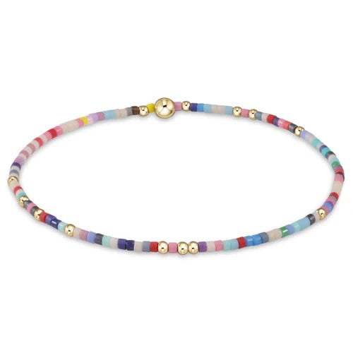 Multicolor beaded bracelet with pink, coral, blue, and gold accents on elastic band