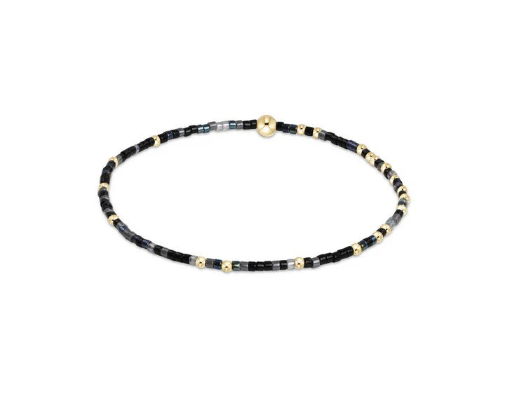 Black and gray beaded bracelet with 14kt gold accents on elastic band