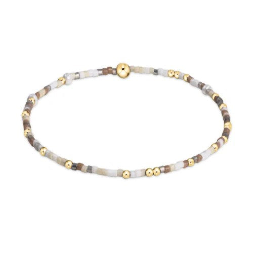 White and gold beaded bracelet with neutral winter tones on elastic band