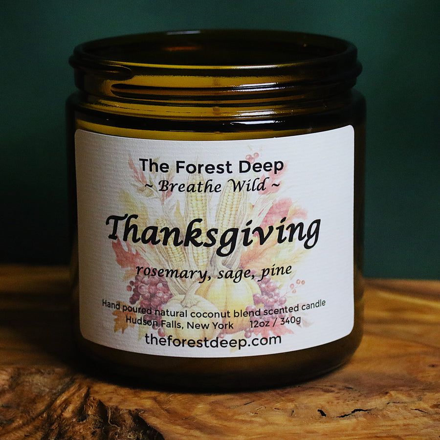 Amber glass candle labeled Thanksgiving with rosemary, sage, and pine notes