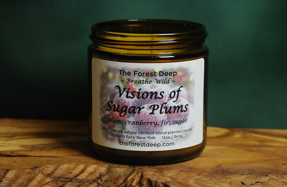 “Visions of Sugar Plums candle by The Forest Deep with plum, cranberry, and fir fragrance label”
