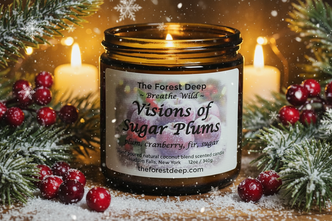Candle jar labeled 'Visions of Sugar Plums' with festive decorations on a wooden surface.