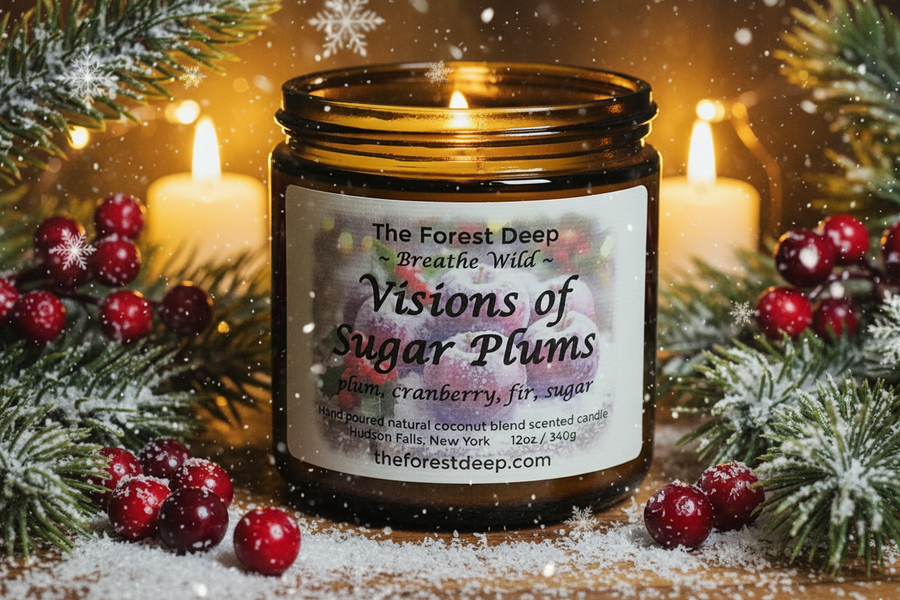 Candle jar labeled 'Visions of Sugar Plums' with festive decorations on a wooden surface.