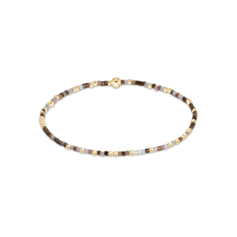 Brown and gold beaded bracelet with soft taupe tones on elastic band